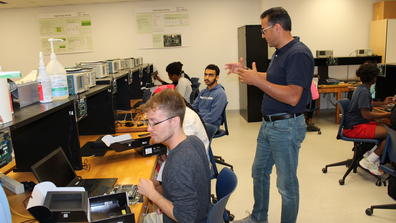 CSU interns unbox and examine the newly arrived Intel FGPGA boards.