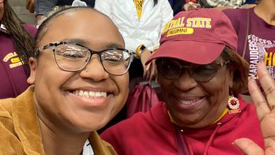 A young woman with her grandmother in Central State University attire of maroon and gold