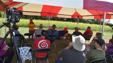 a speaker from Central State University Land-Grant Extension presenting information under a red and white tent at the 61st annual Farm Science Review in London, Ohio
