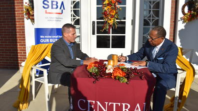 Central State University Interim President Alex Johnson signs a memoradum of understanding while SBA Central and Southern Ohio District Office Director Everett M. Woodel Jr. looks on