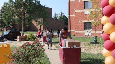 a central state university student pushing a cart with belongings during move-in day