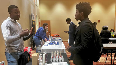 Qi'Marreon Marks talks with a representative of a company at the 2024 career expo at central state university