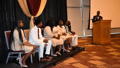 the reverend john c. jones stands at a podium looking toward the student government association executive board