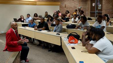 dayton mayor and central state university graduate jeffrey mims sits on a stage while speaking to students in a lecture hall