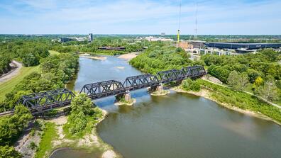 Train bridge over Scioto River with forested area aerial