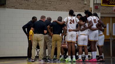 central state university men's basketball team huddles with coaches