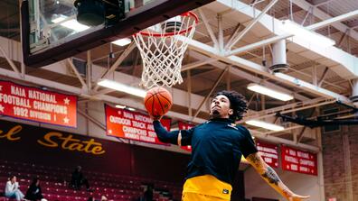 marauder men's basketball player takes a jump shot near the basket during a win over lane college