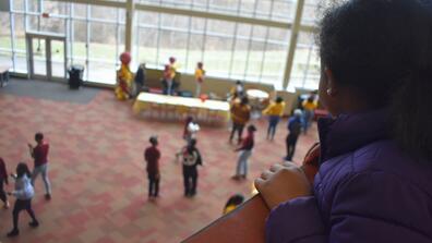 a fifth grader watches marauders dance from the upper level into the lower level of the central state university student center