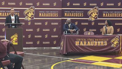 tony carter at podium while president kuti and kevicia brown look on in front of marauder athletics backdrops