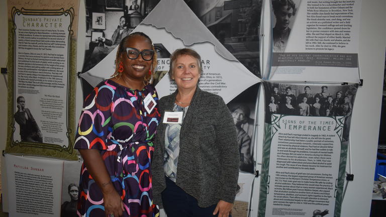 two participants in the 2023 Black Farming Conference pose for a photo in front of a display