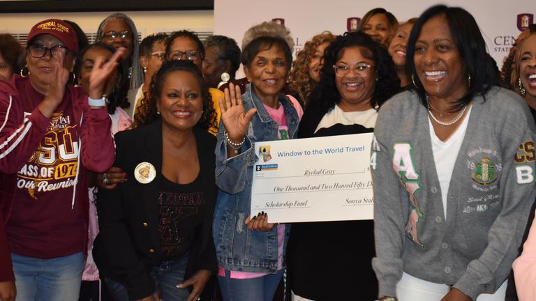 members of alpha kappa alpha with a scholarship check