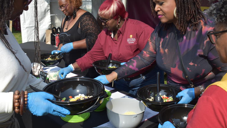 Visiting alumnae join CSU Extension's Sha'Chanda Webster-Davis (second from left), administrative program assistant, in making their do-it-yourself fresh salad at Homecoming Saturday