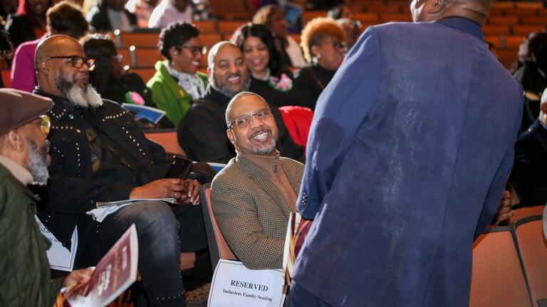 a man smiles surrounded by attendees of charter day