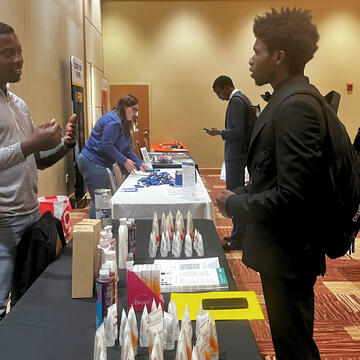 Qi'Marreon Marks talks with a representative of a company at the 2024 career expo at central state university