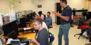 CSU interns unbox and examine the newly arrived Intel FGPGA boards.