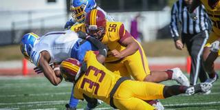 Two football players with Central State University Marauder Athletics tackle an opponent