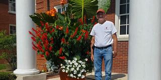 Brian Kampman, vegetable and small fruit crops technician for Central State University (CSU) Extension, stands by a floral display cultivated at CSU including Elephant Ears or Colocasia