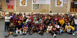 a group of alumni and students in the gymnasium at Central State University