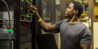 an African American man working on computer hardware technology equipment