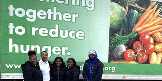 five Central State University students in front of a large semi with the words partnering together to reduce hunger