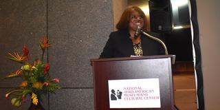Patti Allen stands at a podium at the 2023 Black Farmers Conference held at the National Afro-American Museum and Cultural Center
