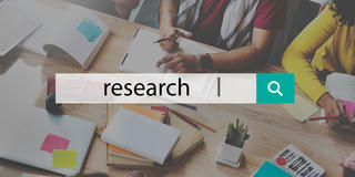 a search engine showing the word research with people working in the background