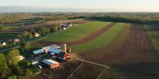 Aerial view of american countryside landscape. Farm, red barn, cows. Rural scenery, farmland. Sunny morning, spring summer season