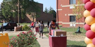 a central state university student pushing a cart with belongings during move-in day