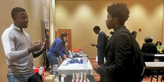 Qi'Marreon Marks talks with a representative of a company at the 2024 career expo at central state university