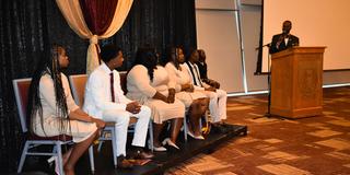 the reverend john c. jones stands at a podium looking toward the student government association executive board