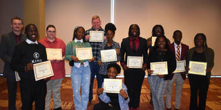 a group of students holding certificates