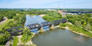 Train bridge over Scioto River with forested area aerial