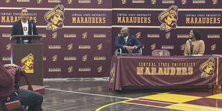 tony carter at podium while president kuti and kevicia brown look on in front of marauder athletics backdrops