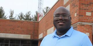 dr. colin lasu outside the central state university mass communications center