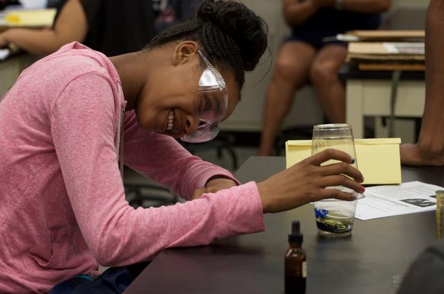 An African American youth wears protective glasses while doing a science experiment at a Central State University Extension summer camp