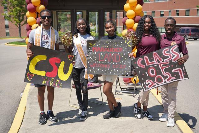 five Central State University students hold signs welcoming the class of 2027 to campus