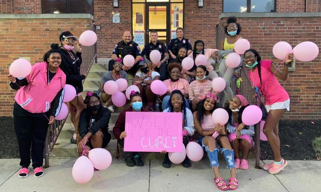 Central State University students hold pink balloons and a sign for breast cancer awareness