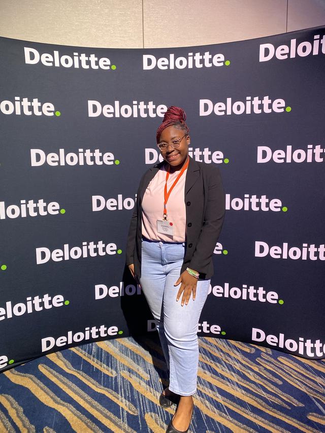 Darriel Russell in front of a Deloitte step and repeat