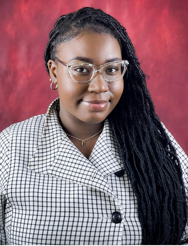 darriel russell headshot shows a young Black woman with long black braids, eye glasses and a checkered shirt