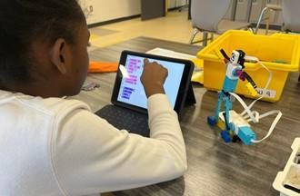 a student in a 4-H summer camp at central state university uses an electronic device