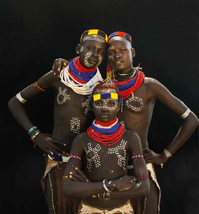 three indigenous african people in traditional clothing