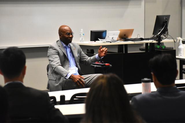 a black man in a suit using a wheelchair