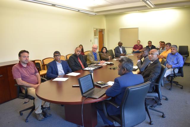 a large group of people sit around a table in a conference room at central state university