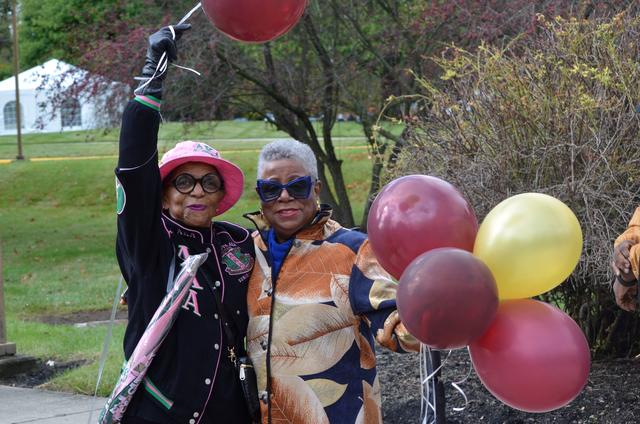 two central state university alumni holding maroon and gold balloons