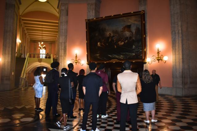 students look at a painting of Perry's Victory depicting a key battle of the War of 1812, The Battle of Lake Erie