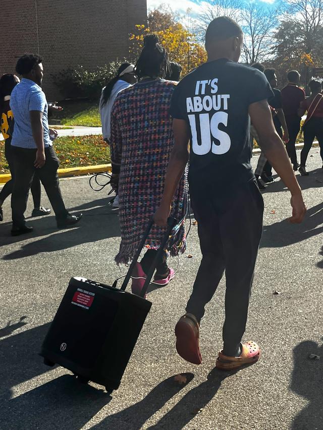 the back of a student wearing a shirt that says it's about us