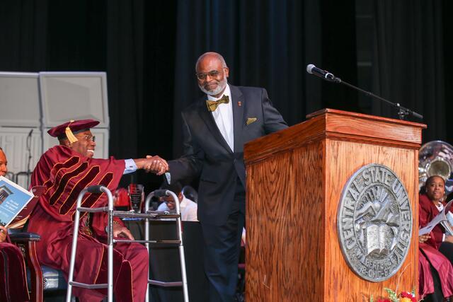 jeffrey elmore leans over to shake hands with central state president dr. morakinyo a.o. kuti